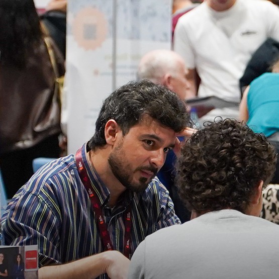 Conversa entre um representante de uma universidade e um visitante na feira Study Abroad Portugal